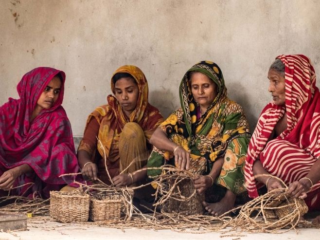 Vier Frauen beim Korbflechten